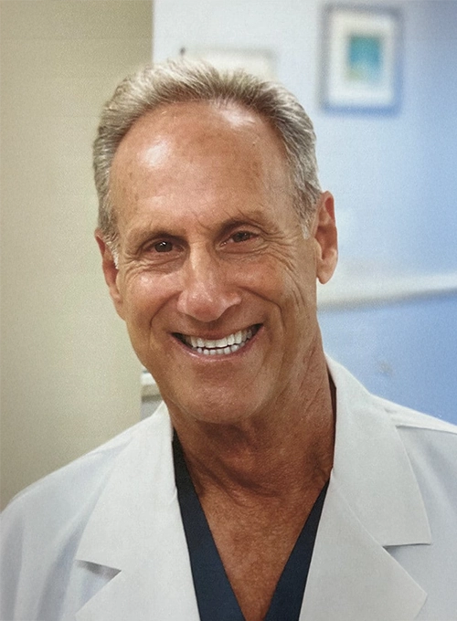 Dentist Anthony Mancino Smiling In Lab Coat